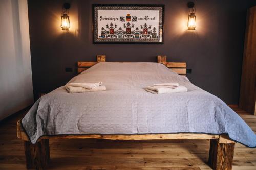 a bedroom with a bed with two towels on it at Daheim in Râşnov