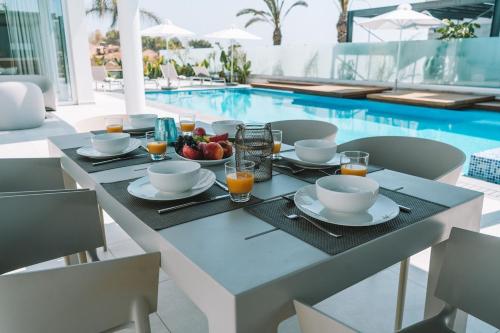 a dining table with a bowl of fruit on it next to a pool at Seaview Luxury Villa Fortuna in Ayia Napa
