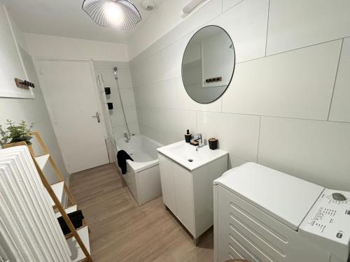 a white bathroom with a sink and a mirror at Appartement spacieux et lumineux, 3 chambres à Coudekerque-branche in Coudekerque-Branche