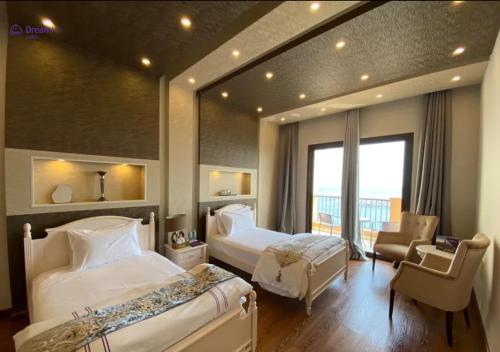 a hotel room with two beds and a chair at Dream Inn Apartments - Luxury 2 BR Mina Al Fajer - Harbor View - Al Fujairah in Rūl Ḑadnā