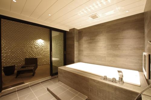 a large bathroom with a tub and a chair at Susukino LOVE HOTEL1-Adult Only in Sapporo
