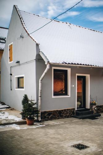 a white house with a tree in front of it at Daheim in Râşnov