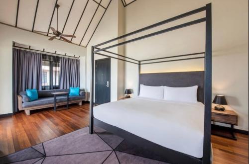 a bedroom with a large bed and a couch at Avani Sepang Goldcoast Resort in Tanjong Sepat