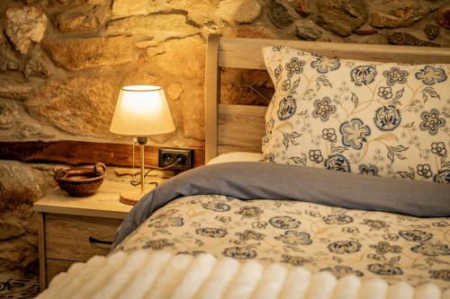 a bedroom with a bed and a table with a lamp at Σοχός Παραδοσιακές Οικίες- ΒΕΝΙΖΕΛΟΥ in Zokhós