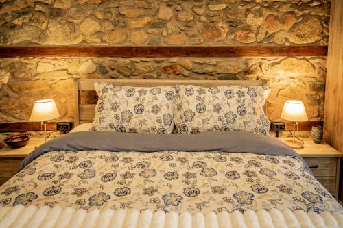 a bedroom with a bed with a stone wall at Σοχός Παραδοσιακές Οικίες- ΒΕΝΙΖΕΛΟΥ in Zokhós