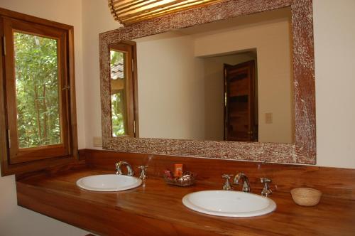 een badkamer met 2 wastafels en een grote spiegel bij Tierra Guaraní Lodge in Puerto Iguazú