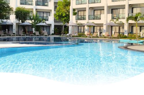 a large swimming pool in front of a building at Pooh Beach Resort & Spa in Jomtien Beach