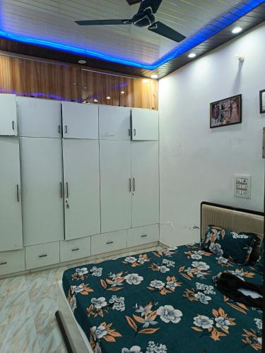 a room with a bed and some white cabinets at Sunbeam Stay in Prayagraj