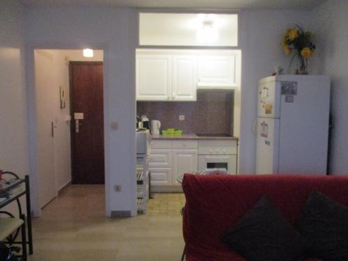 - une cuisine avec un canapé rouge et un réfrigérateur blanc dans l'établissement Riou Cannes Studio, à Cannes