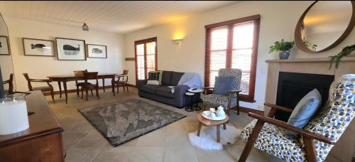 a living room with a couch and a fireplace at Sandstone Suites - In the heart of Port Fairy in Port Fairy