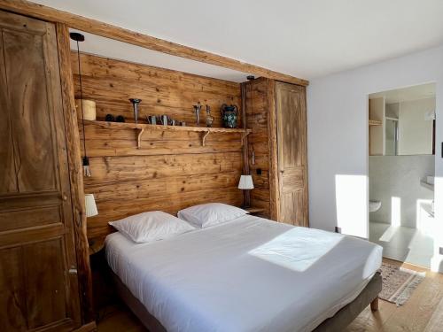 une chambre avec un grand lit avec un mur en bois dans l'établissement Penthouse au cœur de Val Thorens, à Val Thorens