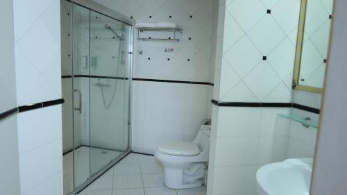 a white bathroom with a toilet and a shower at Guangzhou Aiqun Hotel - Canton Fair Free Shuttle Bus during Canton Fair period in Guangzhou