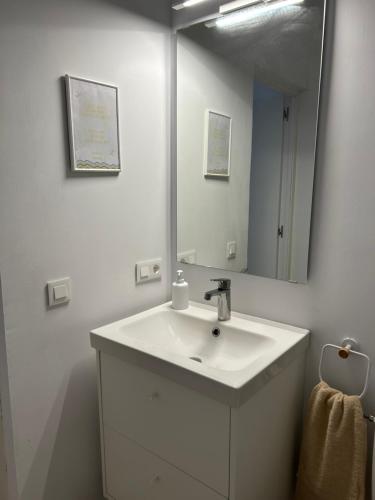a white bathroom with a sink and a mirror at Loft Lugar de Yuco in La Vegueta