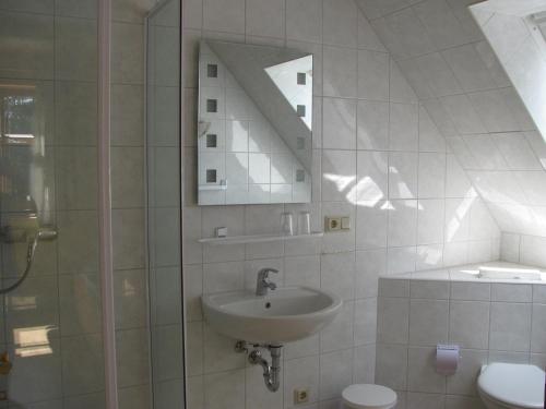 La salle de bains est pourvue d'un lavabo, d'un miroir et de toilettes. dans l'établissement Bismarckschänke, à Burg