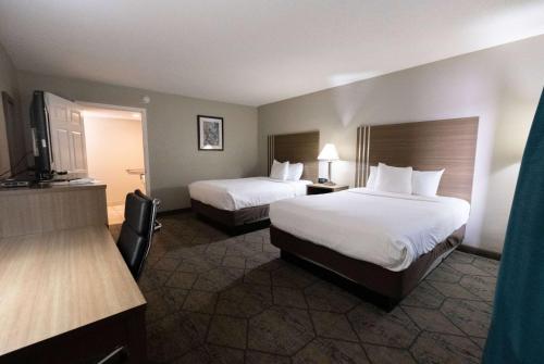 a hotel room with two beds and a flat screen tv at Baymont by Wyndham Effingham in Effingham