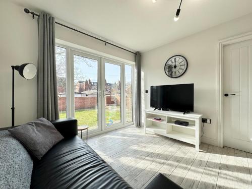 a living room with a couch and a tv at Modern 2 Bedroom Apartment - Near Hospital & Racecourse in Doncaster