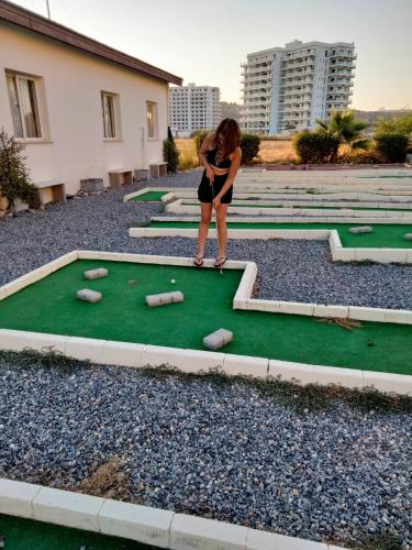 a woman playing a mini golf on a putting green at Charming Kalecik Apartment with Shared Pool and Free Parking in Kalecik