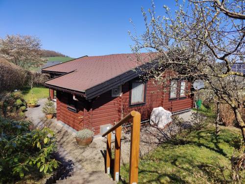 a small red brick house with a brown roof at Ferienhaus Diemelsee-Sudeck in Diemelsee