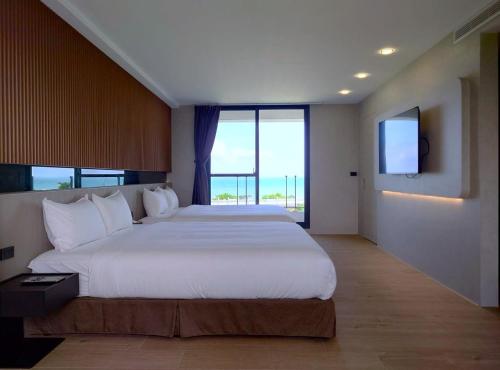 a bedroom with a large bed and a large window at Anchorage Lodge in Jian