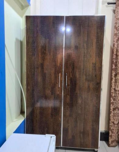a wooden cabinet in a bathroom with a toilet at booking at lodges in Lahore