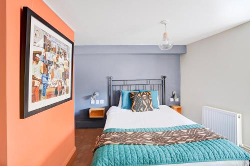 a bedroom with a bed with an orange wall at Dancenter Southwark Near London Bridge in London