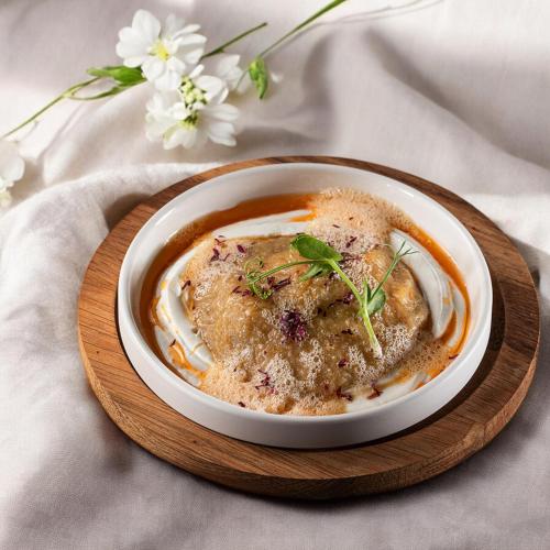 a bowl of food on a wooden plate on a table at Stayso The House Hotel in Istanbul