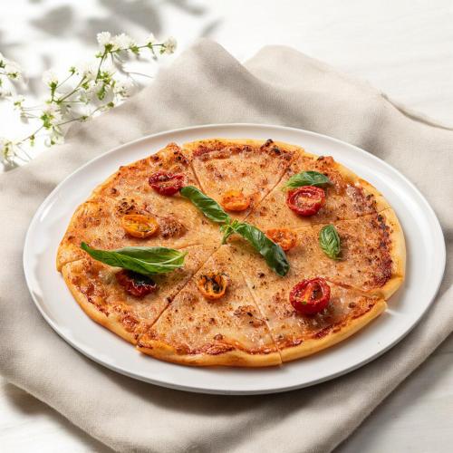 a pizza on a white plate on a table at Stayso The House Hotel in Istanbul