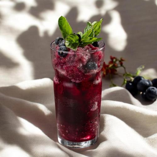 a drink with blueberries and mint on a table at Stayso The House Hotel in Istanbul