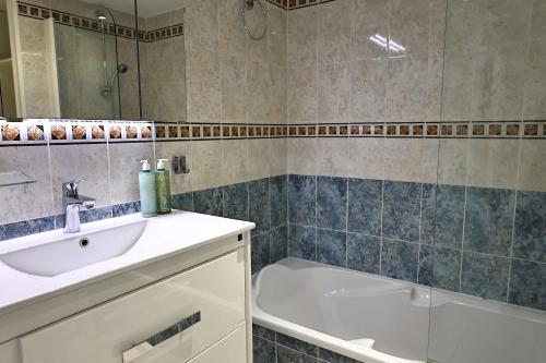 a bathroom with a sink and a bath tub at Évasion Corse - T2 Vue Mer, Piscine & Plage in Ajaccio