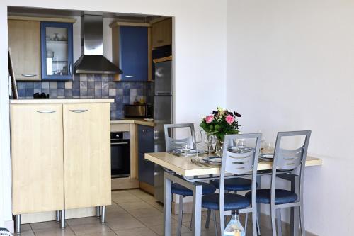 a kitchen with a table and chairs in a kitchen at Évasion Corse - T2 Vue Mer, Piscine & Plage in Ajaccio