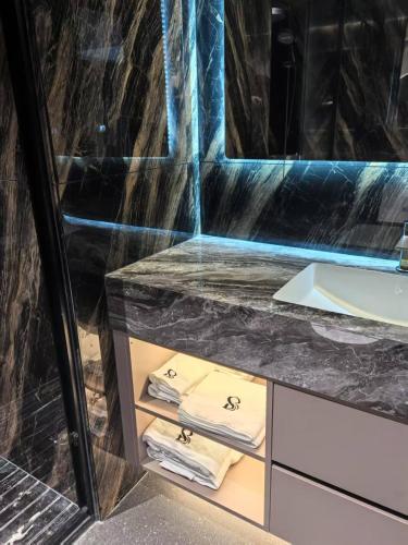 a bathroom with a sink and a counter with towels at 瑞思贝海景精品公寓 in Zhanjiang