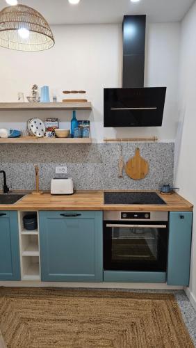 a kitchen with blue cabinets and a stove top oven at Monte View Apartments in Ulcinj