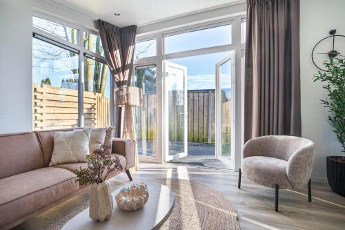 a living room with a couch and a chair at Luxe Relax Lodge Naxos in Heinkensand