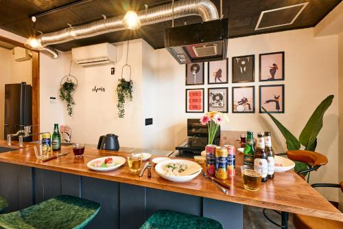a kitchen with a bar with plates of food and drinks at 和氣会々野方 Wakiaiai Nogata in Tokyo