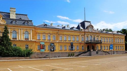 a large yellow building on the side of a street at Rosslyn Thracia Hotel Sofia in Sofia