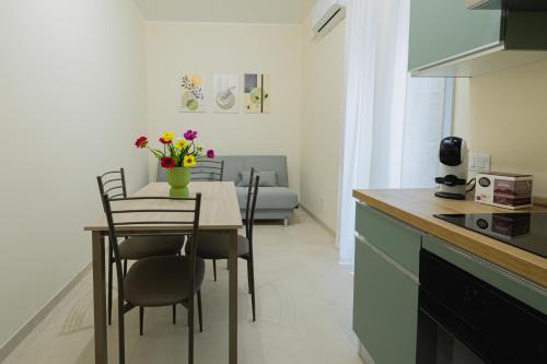 a kitchen with a table and chairs with flowers on it at Makara Awake in Mazara del Vallo