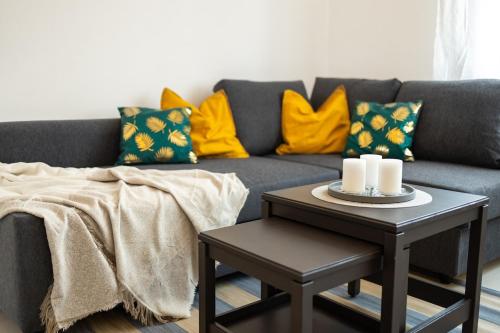 a living room with a gray couch with yellow pillows at Beautiful apartment in city in Medlánky