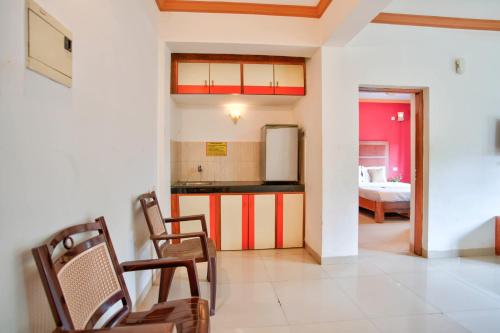 una cocina y sala de estar con sillas y un dormitorio en Nikita Stay Goa, en Calangute