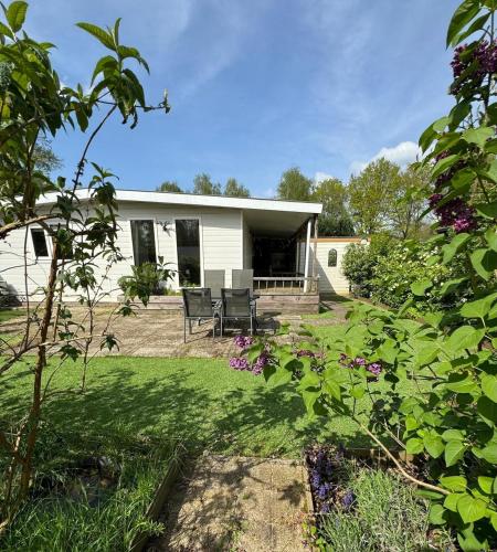 a house with a patio and a yard at Chalet Corbeth in Putten