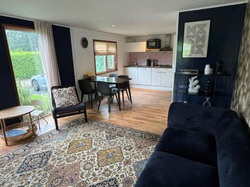 a living room with a table and a dining room at Chalet Corbeth in Putten