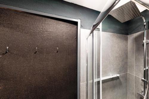a shower with a glass door in a bathroom at Modern Flat by Quokka 360 - In the hills bordering Italy in Vacallo
