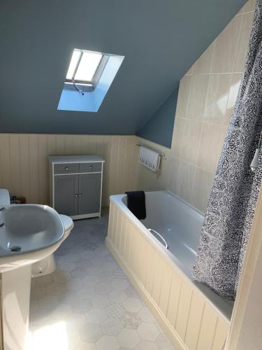 a bathroom with a bath tub and a sink at Golf Cottage in Gullane