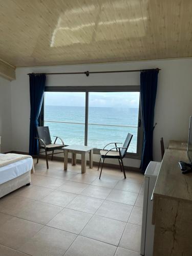 a bedroom with a bed and a view of the ocean at Kaplica Hotel in Mağusa