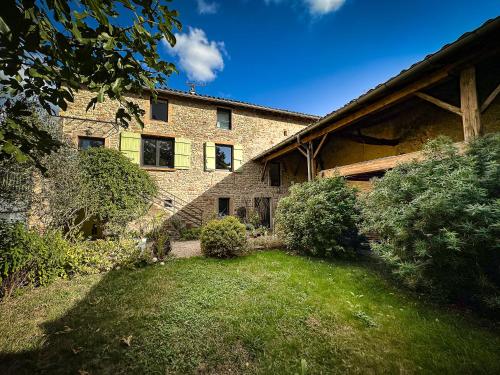 une maison en briques avec une cour devant elle dans l'établissement Le clos de Laly, à Charnay-lès-Mâcon