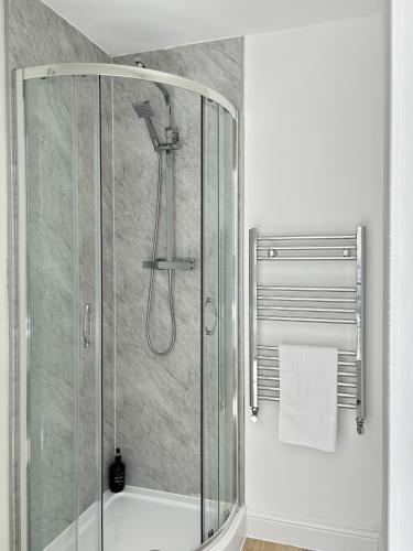 a shower with a glass enclosure in a bathroom at Amaya Nine Sleeps 7 Large 4 bed house - Bottesford in Bottesford