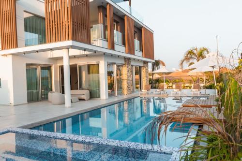 a house with a swimming pool in front of a house at Seaview Luxury Villa Fortuna in Ayia Napa