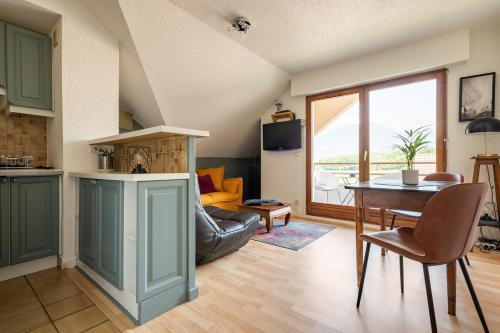 une cuisine et un salon avec une table et un canapé dans l'établissement Le Rive Ouest d 'Annecy, à Saint-Jorioz