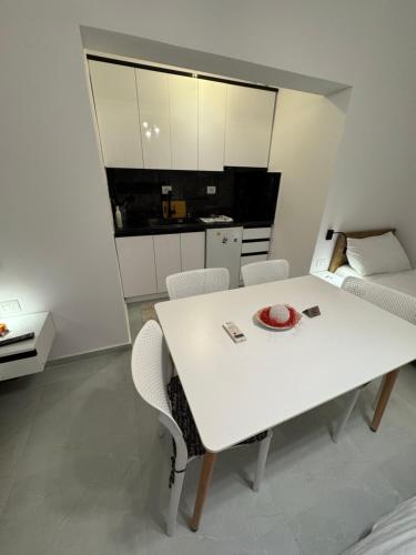 a white table and chairs in a room with a kitchen at Private Villa Aras 2 - Luxury & Elegance Apartments in Vlorë