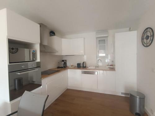 - une cuisine avec des placards blancs et une chaise dans l'établissement appartement dans residence du front de mer - 6852, à Soulac-sur-Mer