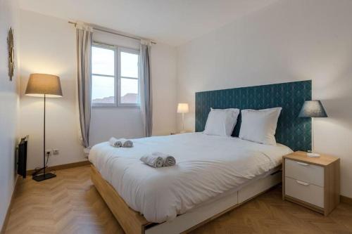 une chambre avec un grand lit avec deux serviettes dessus dans l'établissement Cosy apartment Disneyland BMYGUEST, à Serris